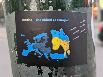 A sticker depicting a map of Europe with Ukraine highlighted in the colors of the Ukrainian flag. Missiles are shown flying towards Ukraine. The text on the sticker reads "Ukraine - the shield of Europe!"