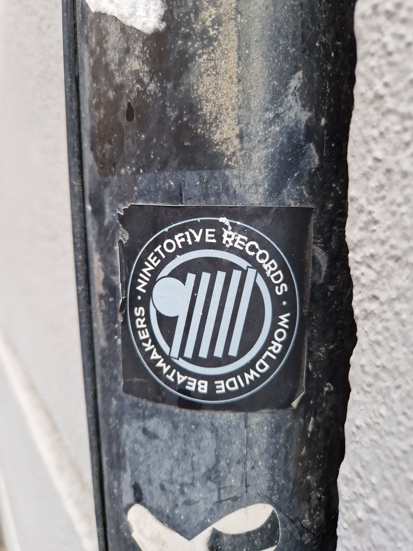 A black and white circular sticker with the text "Ninetofive Records" and "Worldwide Beatmakers" arranged around a central logo. The logo features a circle with vertical lines and a smaller circle to the left.