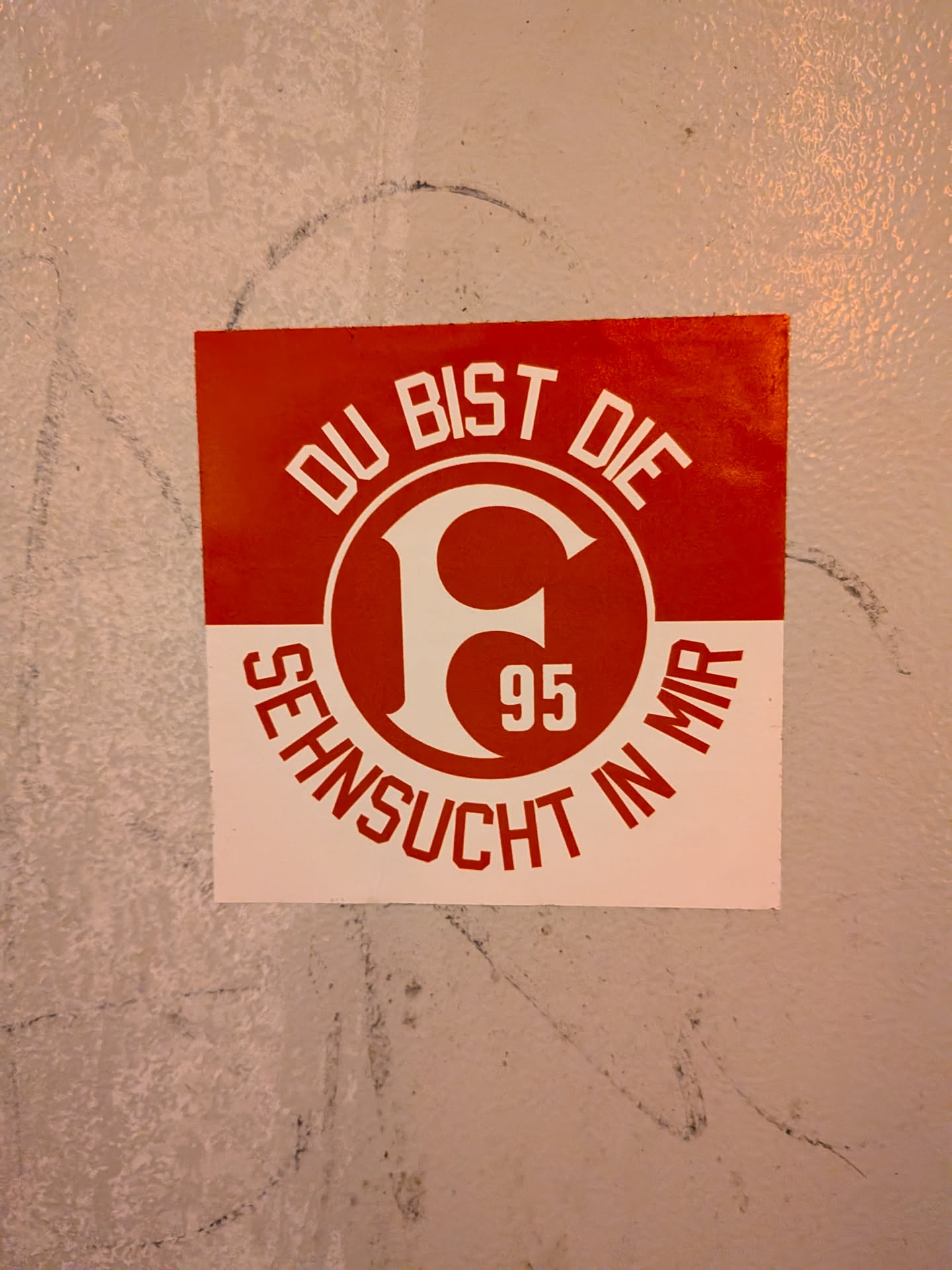 A square football sticker divided horizontally into red and white sections. The top red section features arched white text reading 'DU BIST DIE', while the bottom white section displays arched red text reading 'SEHNSUCHT IN MIR'. In the center sits the circular crest of Fortuna Düsseldorf, showcasing the stylized white 'F' and the number '95' inside a red disc.