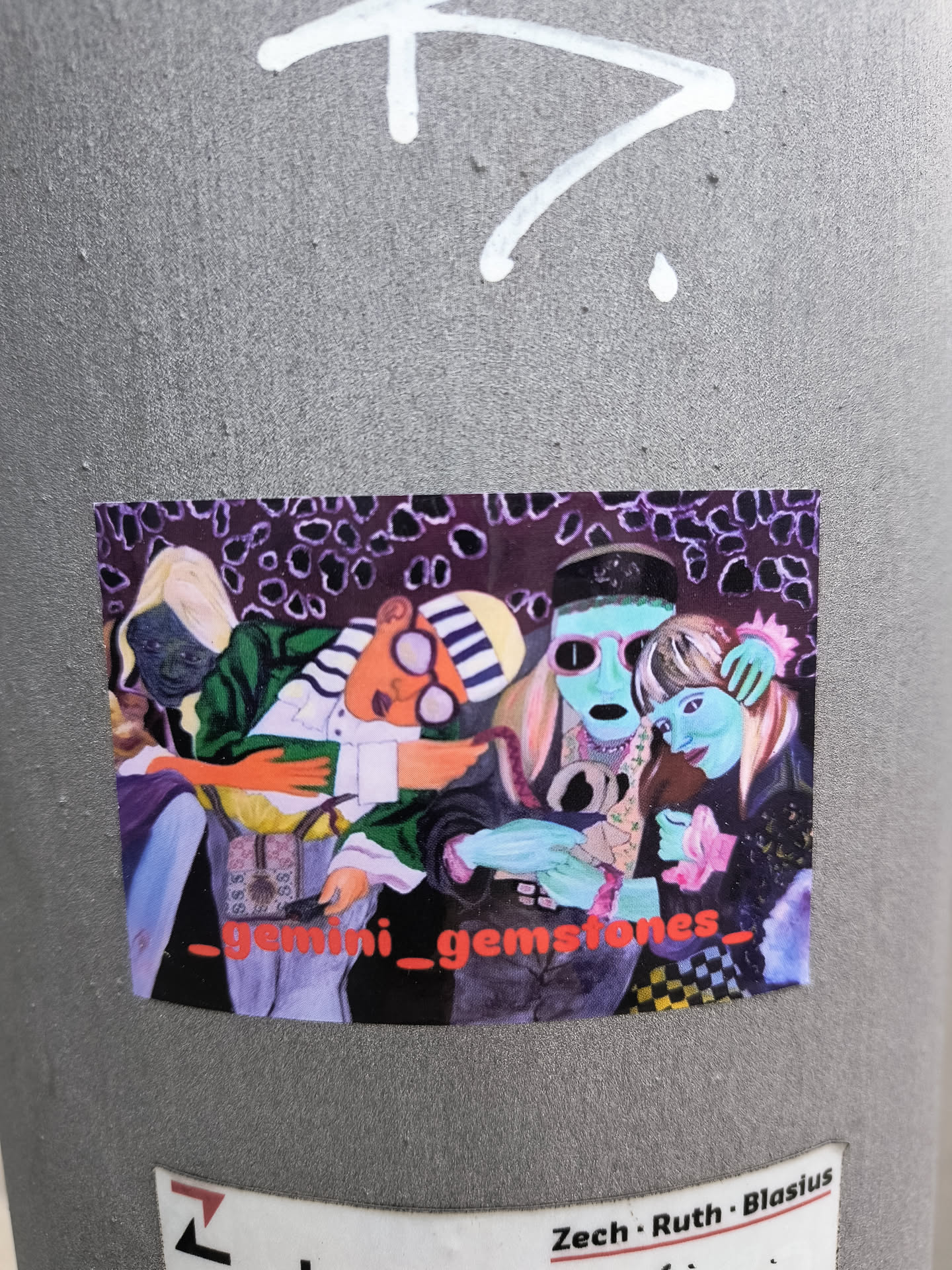 The sticker features a group of stylized characters in a colorful setting. A blond character on the left wears a purple robe and what appears to be some sort of mask. Another character wears a black and white striped hat and strange glasses. There's a tall character in the center with a greenish-blue face, wearing a black hat. A character on the right with blue skin holds pink flowers. The background is dark with a pattern of purple circles. The words '_gemini_gemstones_' are written across the bottom of the sticker. The style is artistic and illustrative.