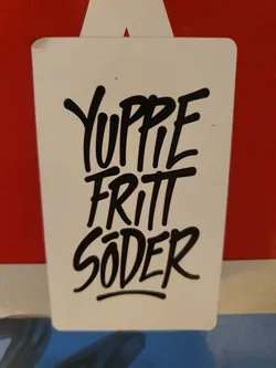 White rectangular sticker with black graffiti-style text. The text says "YUPPIE FRITT SØDER".