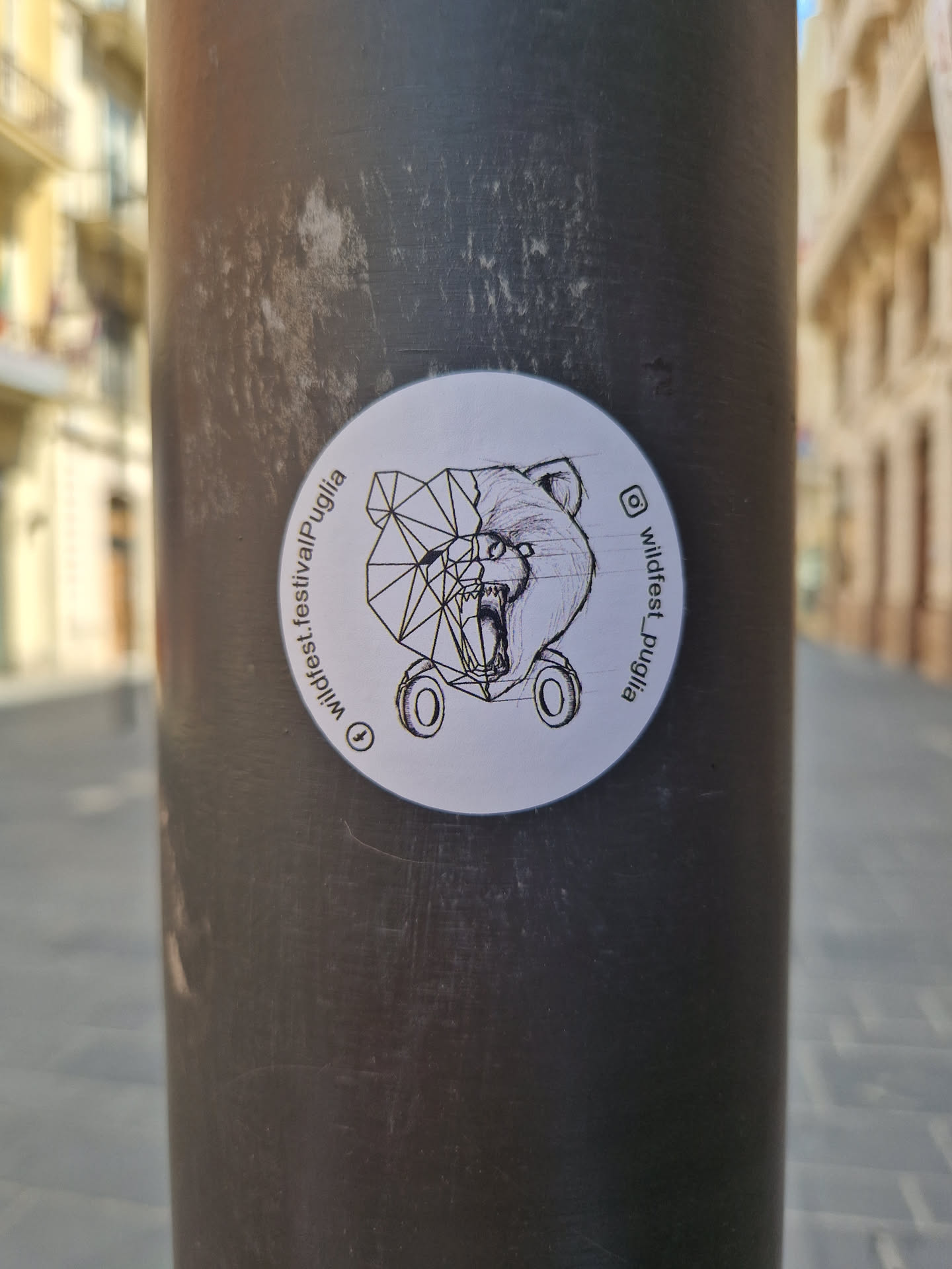 Sticker featuring a geometric bear illustration. The sticker includes the text "Wildest_Puglia" and the Instagram handle @wildfest_puglia.