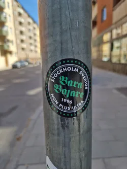 A round sticker with the text "STOCKHOLM SVERIGE" at the top and "Bara Bajare" in a stylized font in the center.  The year 1996 and "NON PLUS ULTRA" are written below.  The sticker has a dark background with green text and white stars.