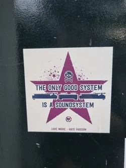 A sticker featuring a purple star with a skull and crossbones, sound system graphic, and the text "The only good system is a soundsystem."  Below is the text: "Love Music - Hate Fascism"