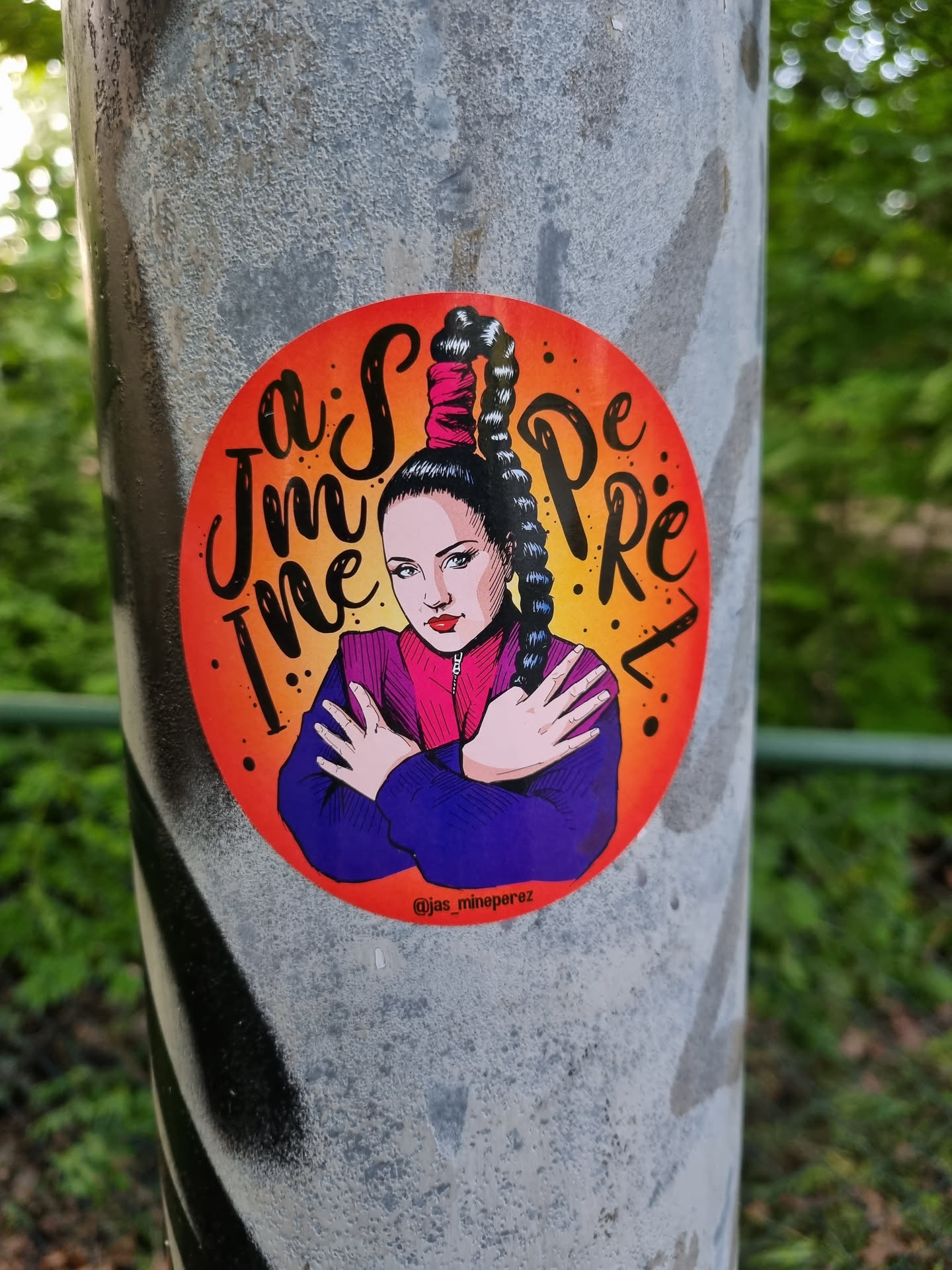 Round sticker featuring an illustration of a girl with a high ponytail, wearing a purple jacket. The background is orange with the text "Im the super girl" written in a stylized font.