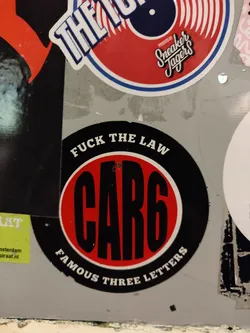 Street sticker Round sticker with black and red colors. It says CAR6 in big black letters on a red circle. Around the circle it says in smaller letters "FUCK THE LAW" and "FAMOUS THREE LETTERS".