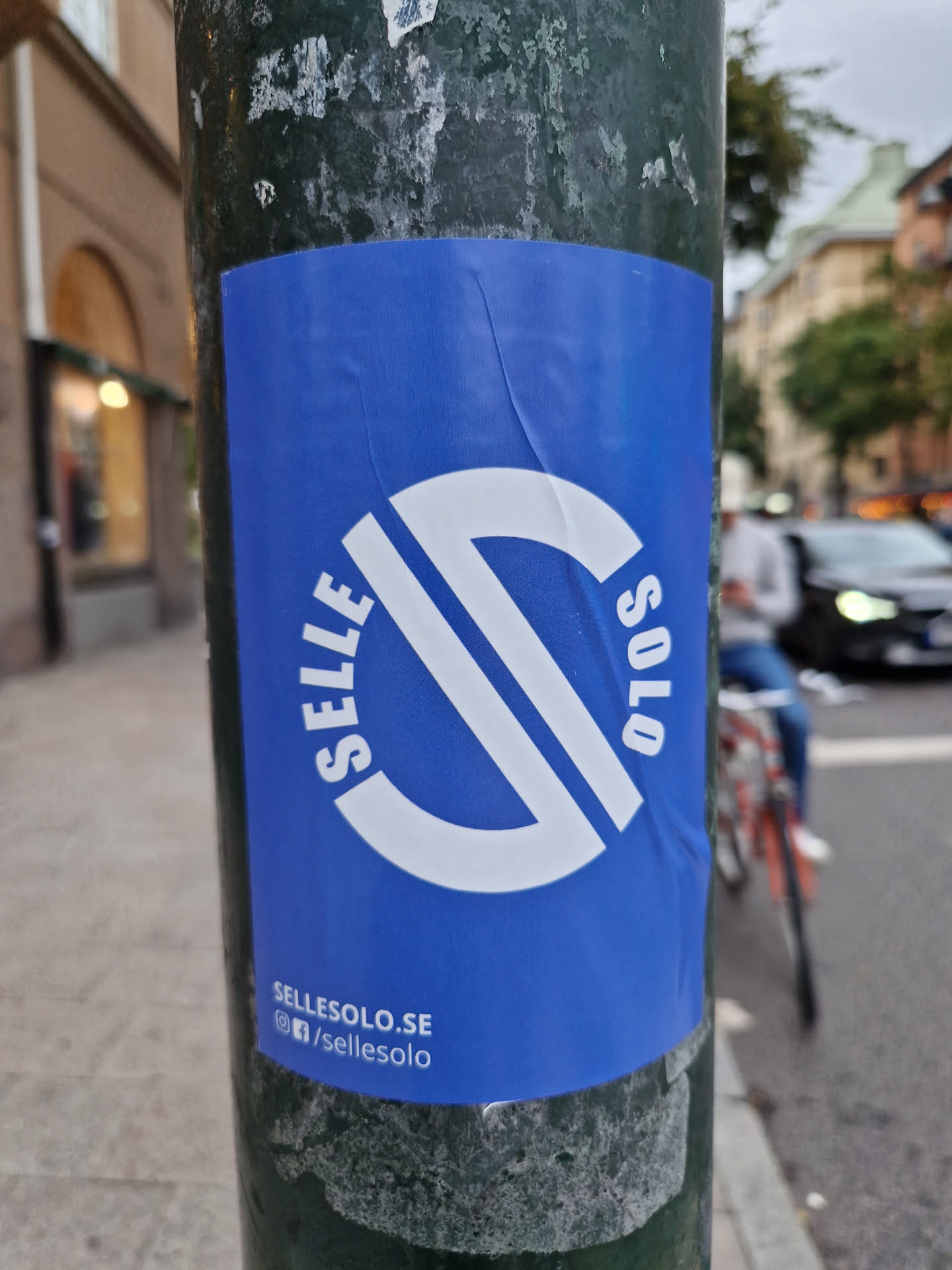A blue sticker with a white logo that says SelleSolo.  The website and social media handles are listed at the bottom. The logo is a stylized 'S' inside a circle.