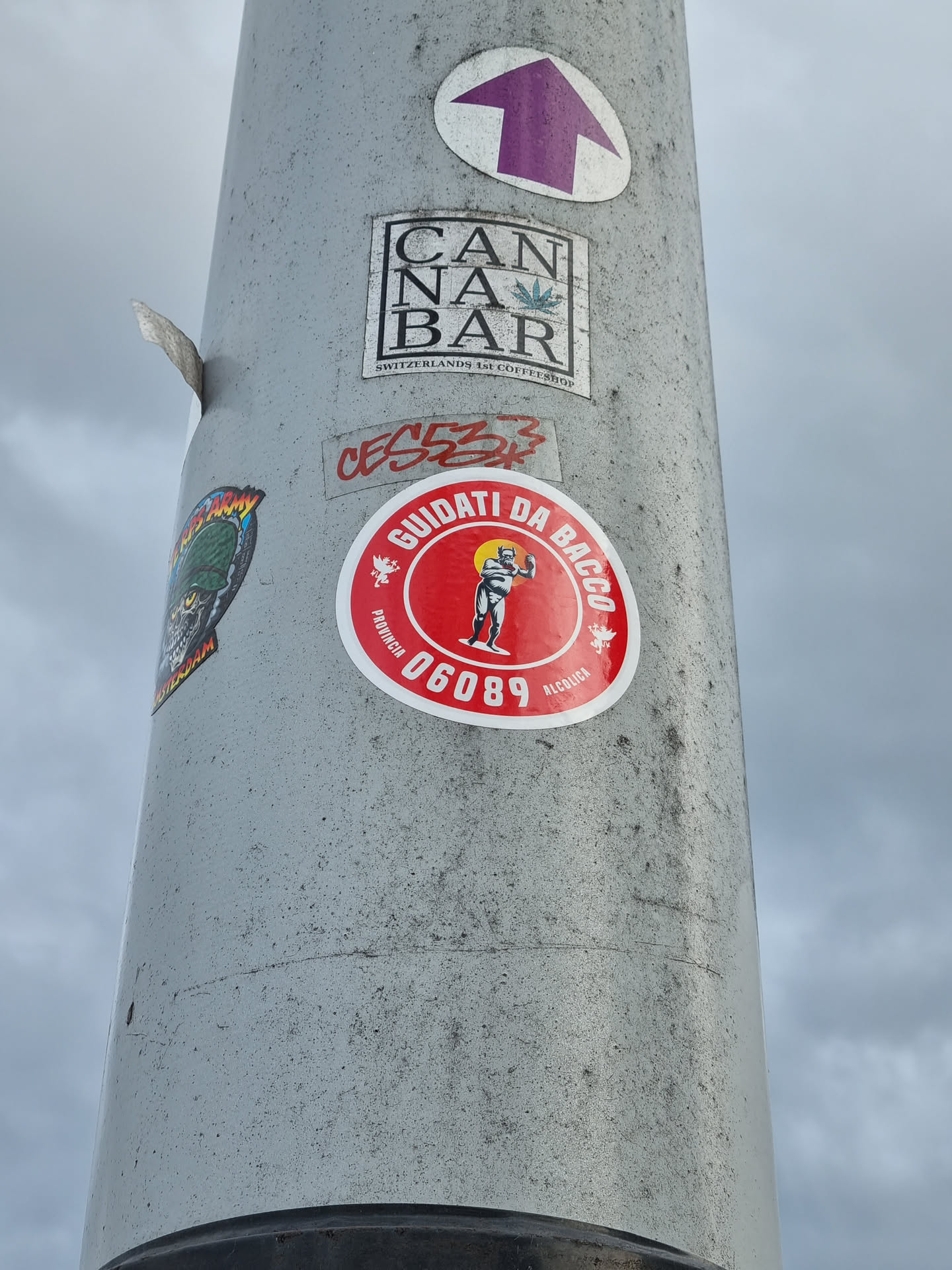 A red round sticker with a figure and text in Italian. The text translates to "Guided by Bacchus." It also has a number 06089.