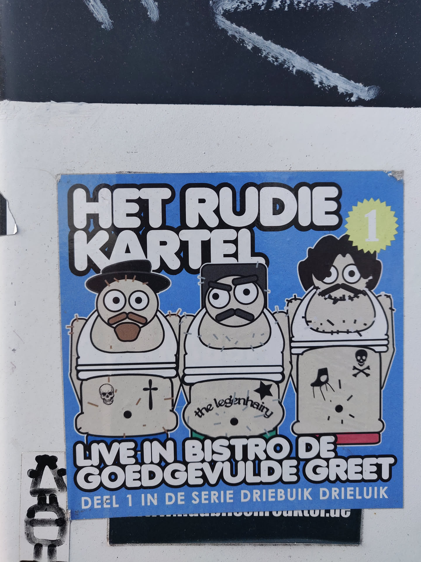 Sticker featuring three cartoon characters with tattoos, announcing a live event at Bistro de Goedgevulde Greet.  This is part 1 of a three-part series.