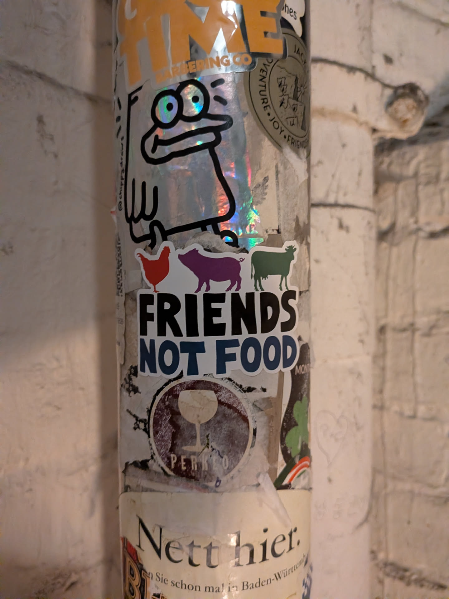 A die-cut sticker featuring three colorful silhouettes of farm animals standing in a line: a red chicken on the left, a purple pig in the center, and a green cow on the right. Below the animals, the bold text reads 'FRIENDS' in black capital letters stacked above 'NOT FOOD' in dark blue capital letters, all surrounded by a white die-cut border.