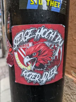 A red sticker with a illustration of an eagle and text that says "Steige hoch du roter adler".