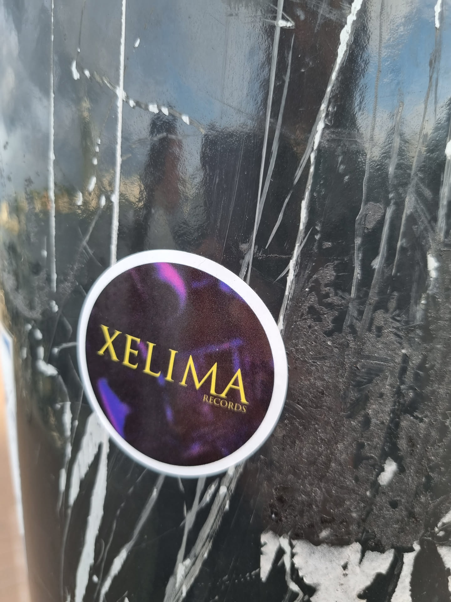 Round sticker with a dark background and a holographic effect.  The text 'XELIMA RECORDS' is prominently displayed in gold lettering. The sticker appears to be vinyl or a similar material.