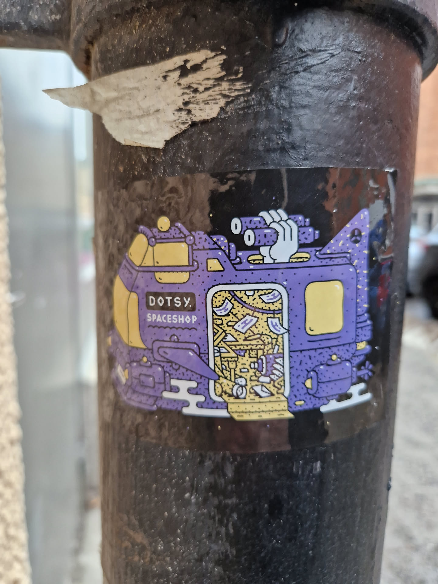 A sticker featuring a whimsical illustration of a spaceship filled with various objects. The style is reminiscent of retro-futurism with a playful touch.