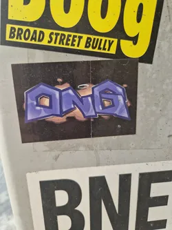 A sticker with graffiti-style lettering spelling 'ONG' in purple with a dark background. The letters have a bubbly, 3D effect.