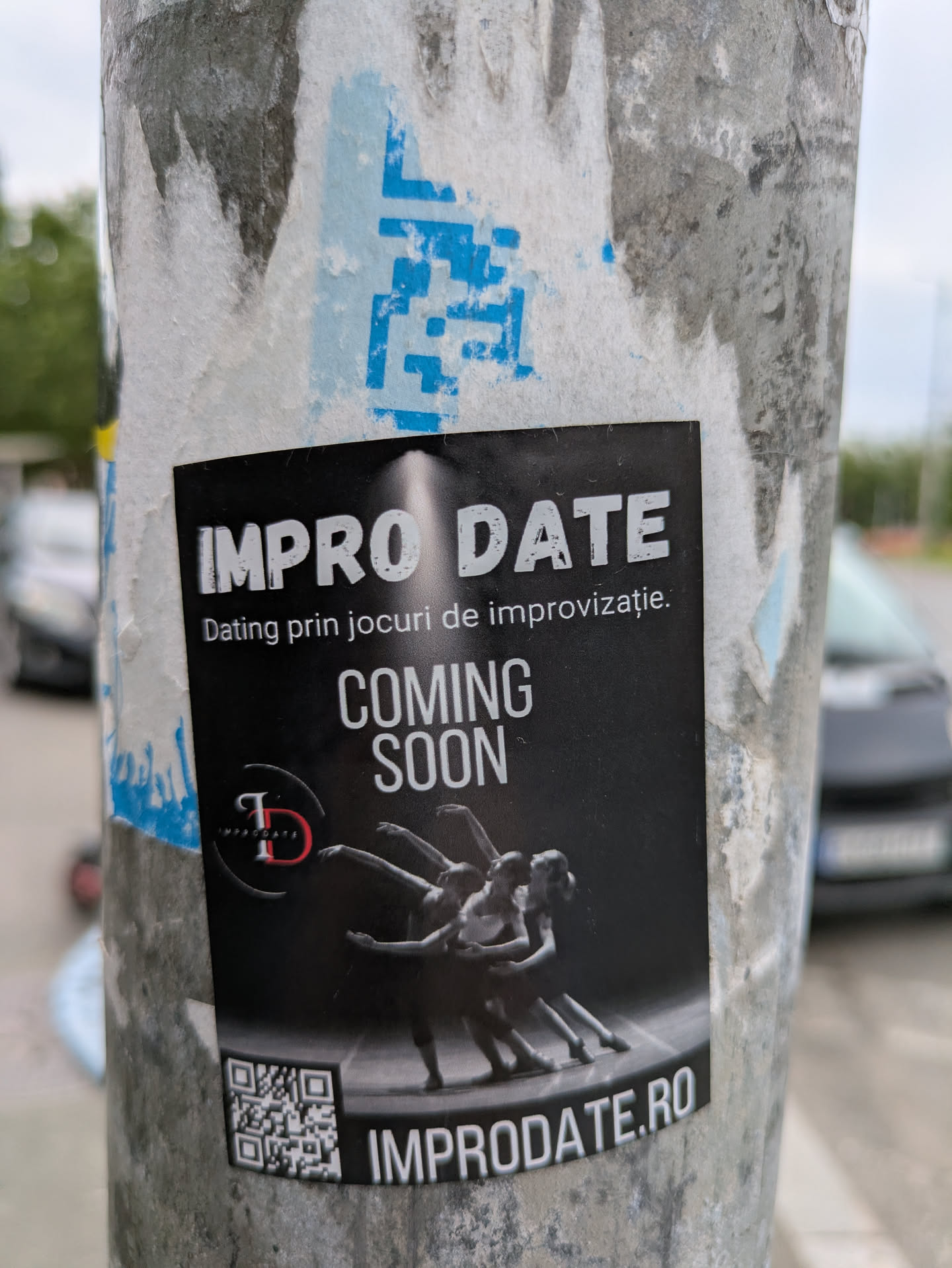 The sticker features a black background with white sans-serif font stating 'IMPRO DATE' at the top and 'Dating prin jocuri de improvizatie.' beneath it. The text 'COMING SOON' is prominently displayed. A blurred black and white image of dancers is displayed above a QR code and the website address 'IMPRODATE.RO'.