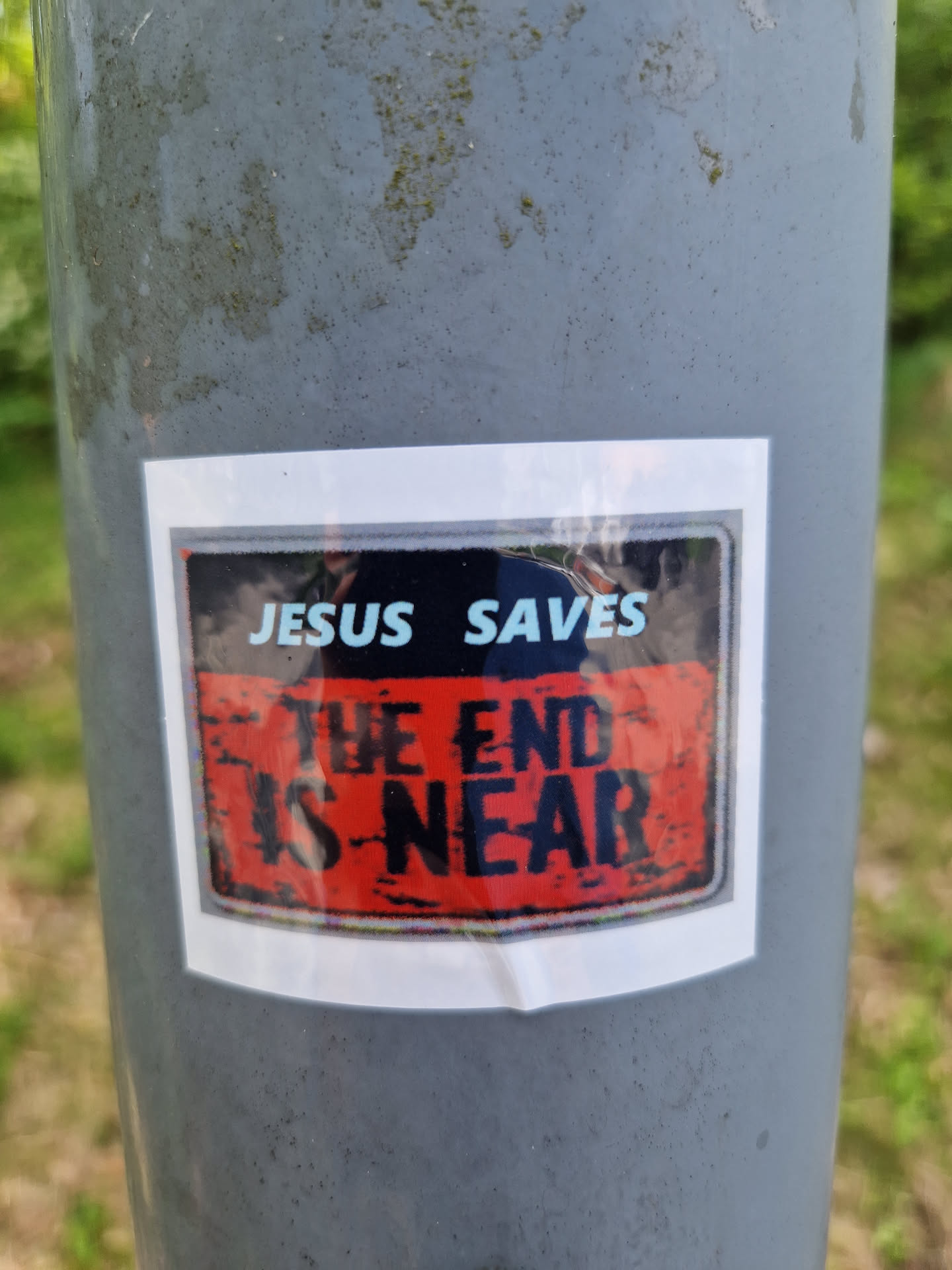 A sticker featuring a religious message. The text on the sticker says "Jesus Saves" and "The End Is Near". The sticker has a distressed, vintage look.