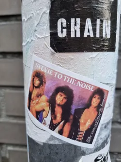 A sticker featuring a glam metal band, possibly the band itself named Stevie to the Noise.  The image is a promotional shot reminiscent of 80s album art. Three band members are shown. 