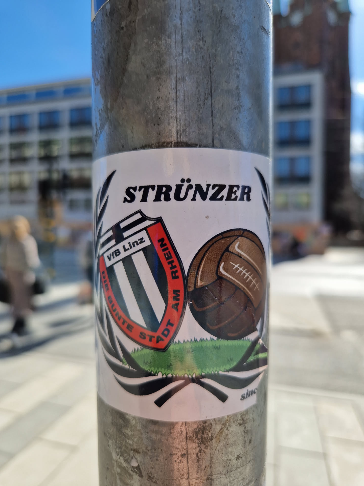 A sticker featuring the logo of VfB Linz, a football club from Linz, Austria. The sticker also includes the word "Strünzer" and an illustration of a vintage football.