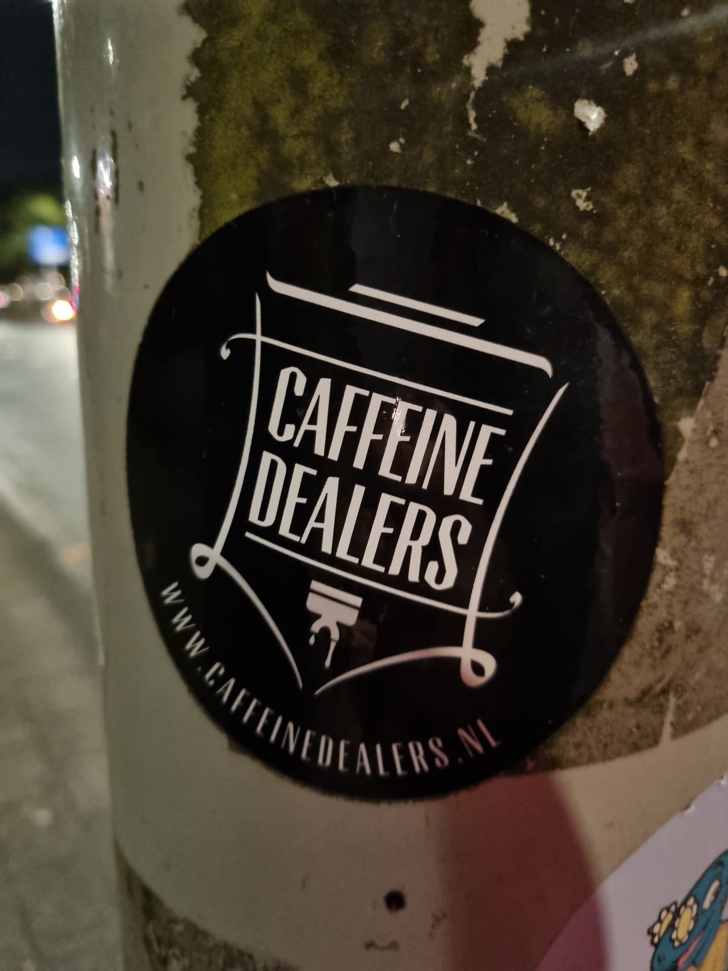 A black and white sticker with the text "Caffeine Dealers" in a stylized font.  The website www.caffeinedalers.nl is also printed on the sticker.