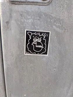 A square-shaped sticker featuring a stylized, angry-looking face or creature in white outline against a solid black background. The character has furrowed brows, narrow eyes, and an open mouth revealing sharp, triangular teeth. Its head is surrounded by a wavy, cloud-like or shaggy outline. A thin white border frames the design. The text 'SoEM' is visible in the bottom left corner, and '24.' is in the top right.