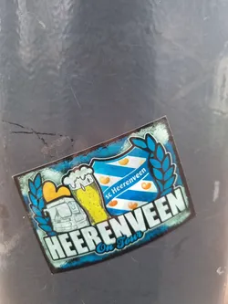 A sticker featuring the logo of SC Heerenveen, a Dutch football club, along with imagery suggesting a tour or travel theme.  It includes a beer stein, a bus, and the club's crest.