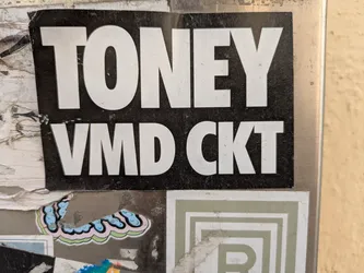The sticker is black with white letters. The text reads "TONEY" on top and "VMD CKT" below it.