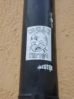 A black and white sticker featuring a crying baby illustration. The text on the sticker says "NO CLASS TATTOO" with the word "SISTER" written below the main illustration.
