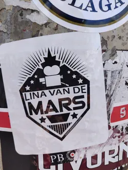 Black and white sticker with a logo featuring a film camera and stars.  The text 'Lina Van De Mars' is prominently displayed.