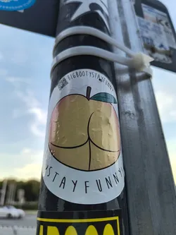 A sticker featuring a peach-shaped bottom with the text "Big Booty Stay Funny".