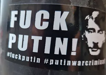 Black and white sticker with the text "FUCK PUTIN!" and a stylized portrait of Vladimir Putin.  The hashtags #fuckputin and #putinwarcriminal are also visible.
