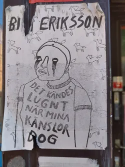A black and white drawing of a person with tears running down their face. The person is wearing a sweater with text on it that says "Det känns lugnt när mina känslor dog" which translates to "It feels calm when my feelings die". The background is filled with small drawings of horses. The sticker is signed "BI ERIKSSON".
