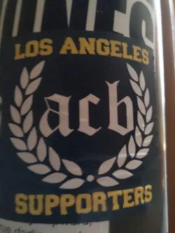 A black and white sticker with a laurel wreath surrounding the letters ACB in a medieval-style font.  The words "LOS ANGELES" and "SUPPORTERS" are written in yellow above and below the emblem respectively.