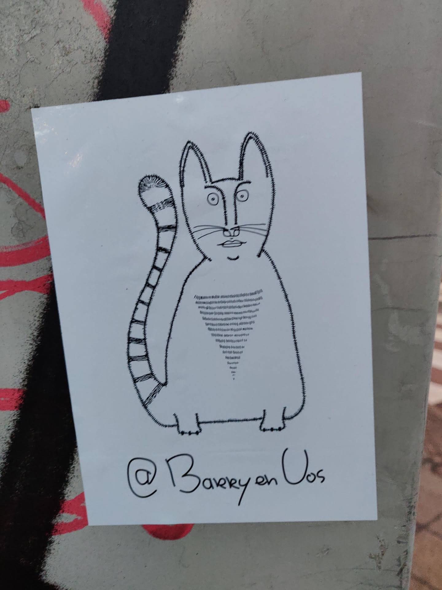 A hand-drawn illustration of a cat with a striped tail. The style is simple and minimalistic, with black lines on white paper. The artist's Instagram handle is written at the bottom.