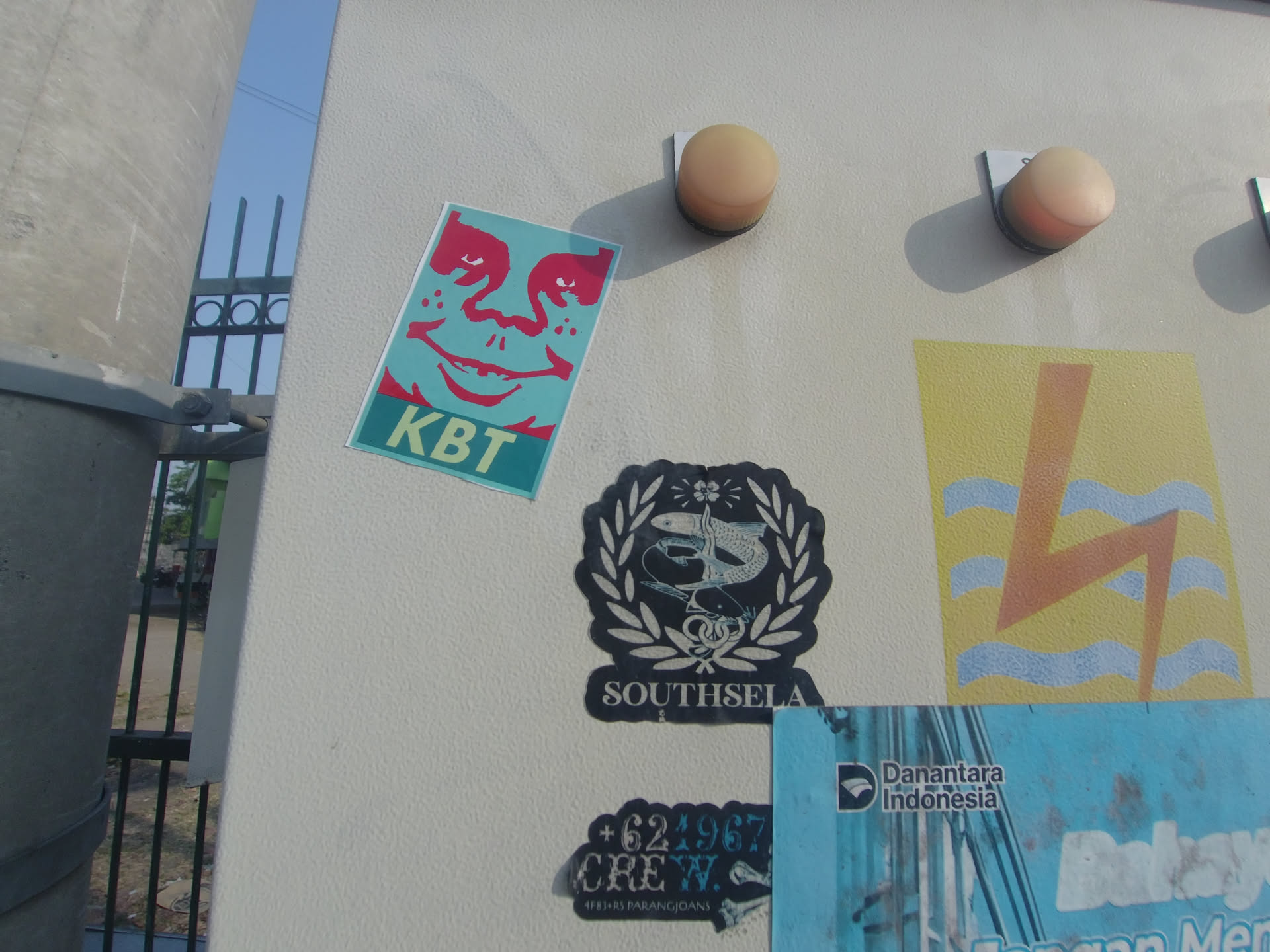The sticker is a die-cut black crest emblem featuring white illustrations. At its center is a fish entwined with a hook and line, framed by a prominent laurel wreath. At the top of the wreath is a small flower motif, and along the bottom is a banner containing the capitalized text 'SOUTHSELA' in a bold serif typeface.