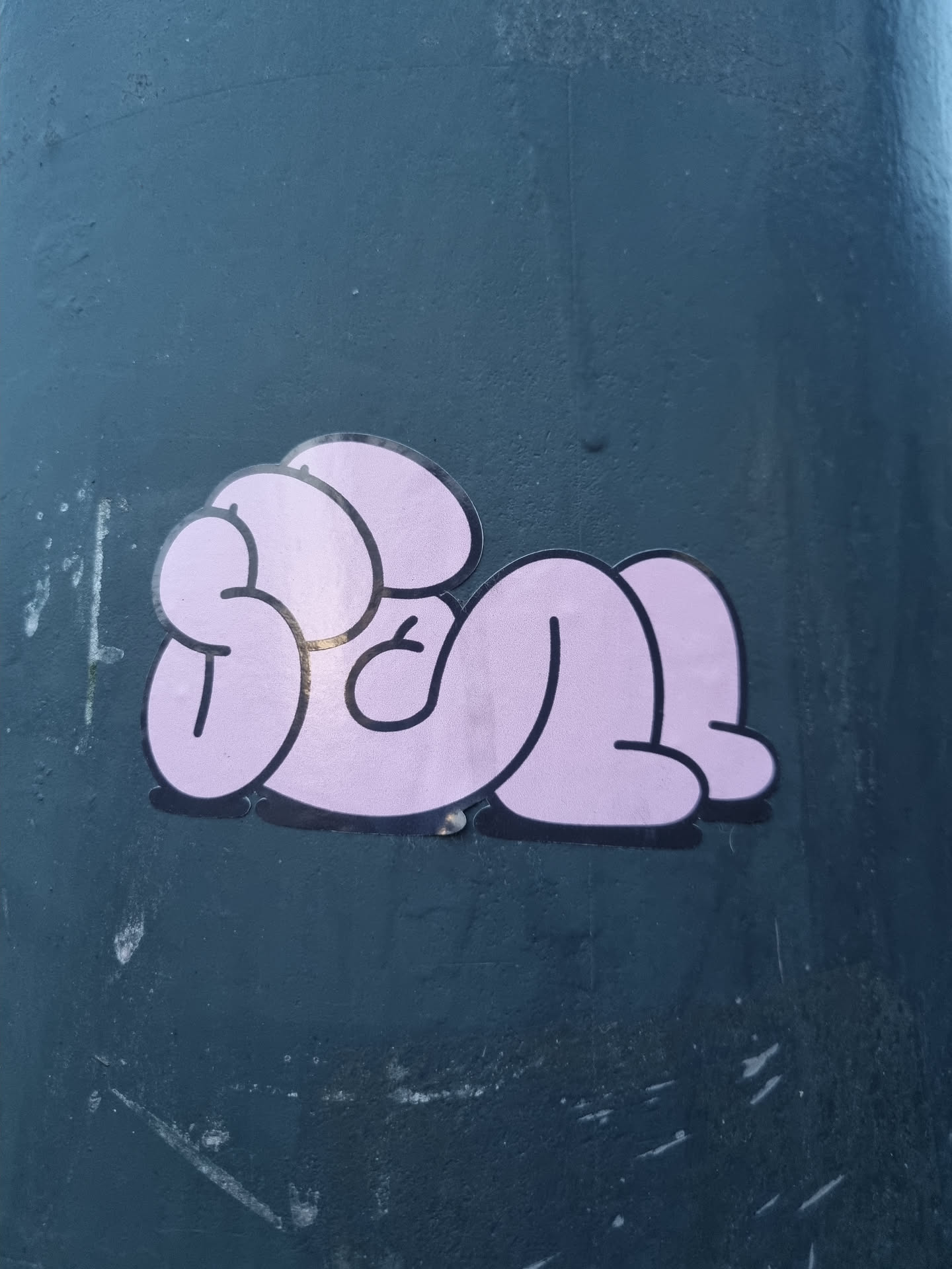 A sticker of a pink figure in a laying position. The character is depicted in a simple, cartoonish style with rounded shapes and minimal details.