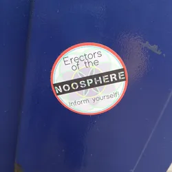 A round sticker with a red border and light green background. It has the text 'Erectors of the NOOSPHERE' written in black with a holographic effect. Below it says 'Inform yourself!' in a smaller font.