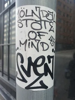 A sticker with graffiti-style text on a metal pole. The text says "Mölndal States Of Mind" and "Sven".