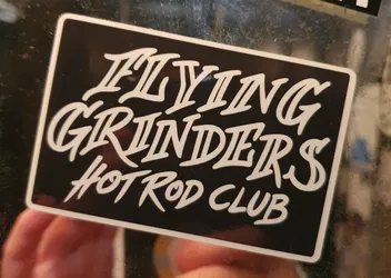 Black and white sticker with the text "Flying Grinders Hot Rod Club" in a stylized script font.