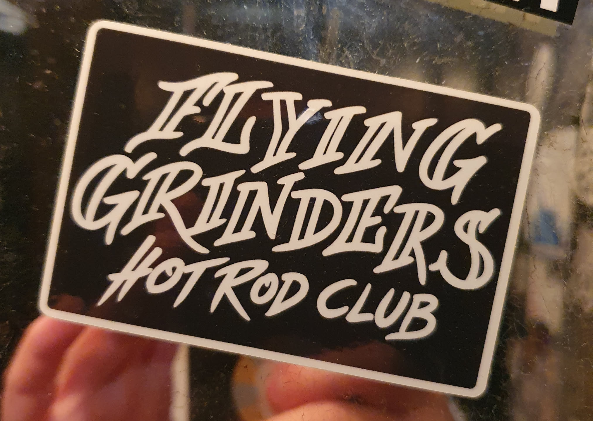 Black and white sticker with the text "Flying Grinders Hot Rod Club" in a stylized script font.