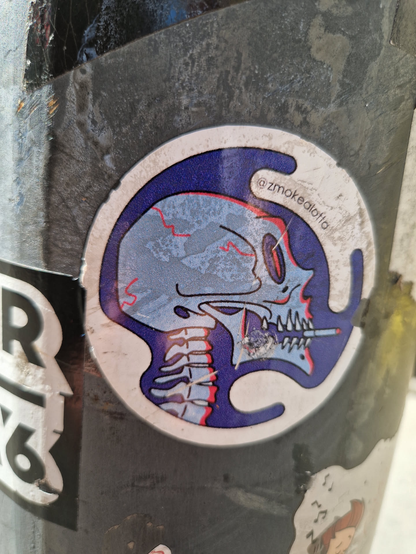 A sticker featuring a detailed illustration of a skull's head and neck, seemingly smoking a cigarette. The skull is rendered in shades of blue and grey, with the background a darker blue. The style is somewhat reminiscent of anatomical illustrations.  The artist's Instagram handle is visible in the sticker: @zsmokedlattia.
