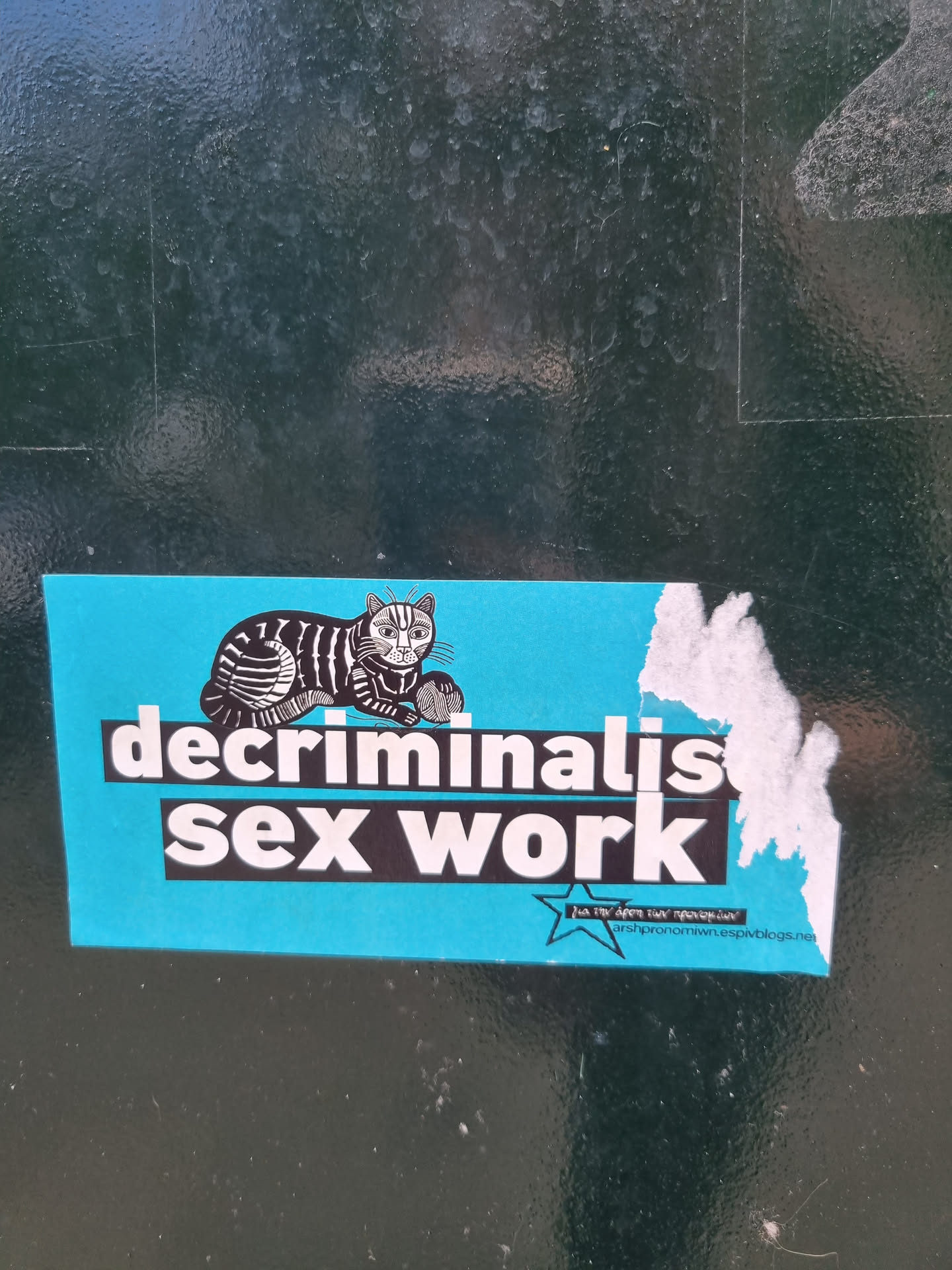 A light blue sticker featuring a cartoon cat and the text "decriminalise sex work". There is also a website address at the bottom.