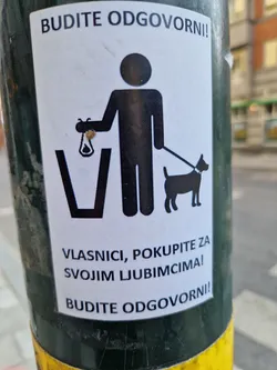 A sticker promoting responsible pet ownership.  It depicts a pictogram of a person picking up dog waste and placing it in a bin. The text is in Croatian.