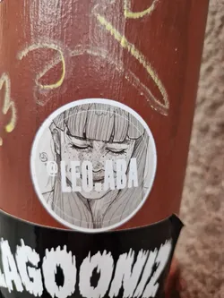 Round sticker featuring a grayscale sketch of a woman's face. The artist's Instagram handle is printed at the bottom of the sticker.