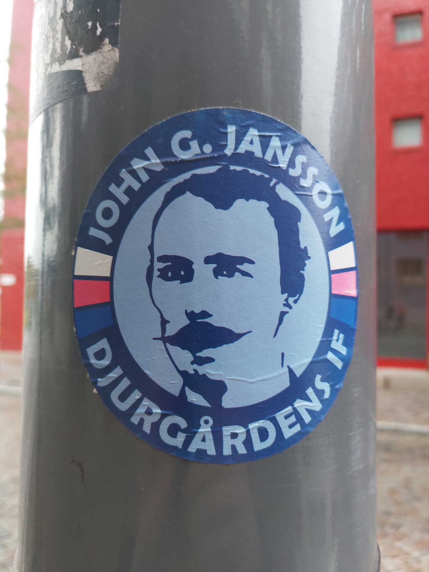 A round blue sticker with a portrait of John G. Jansson and the text "John G. Jansson Djurgårdens IF".