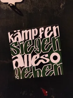 A dark green and white sticker with German text. The text is stylized in a graffiti-like font.  The words translate to "fight win give everything".