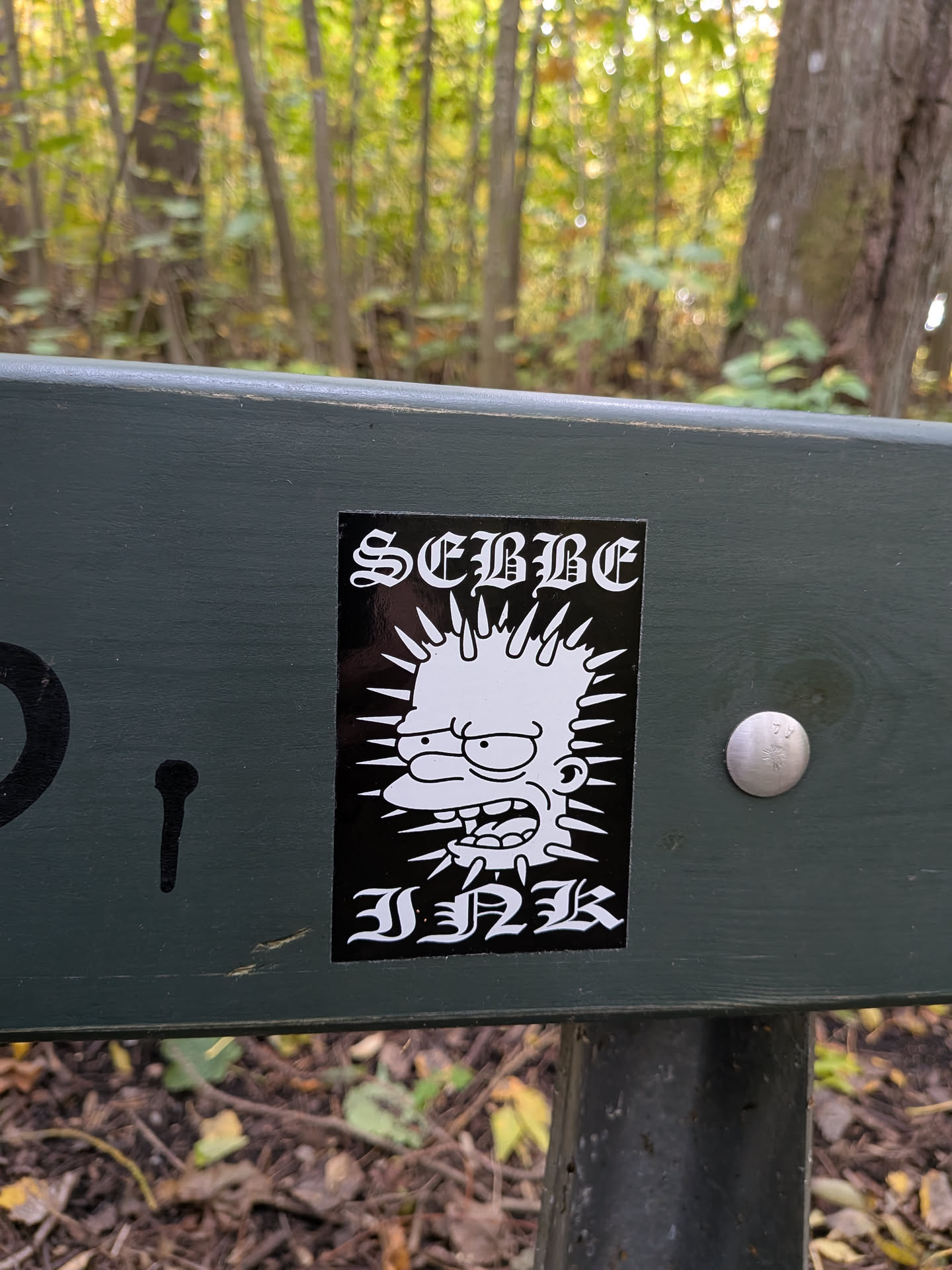 The sticker is black and white, featuring a stylized depiction of Bart Simpson from The Simpsons. His hair is depicted as spiky rays emanating from his head, and he has a wide, aggressive grin with his tongue sticking out. Above Bart's head, in a gothic-style font, is the word 'SEMME'. Below Bart's head, also in a gothic-style font, is the word 'INK'. The overall impression is edgy and punk-inspired.