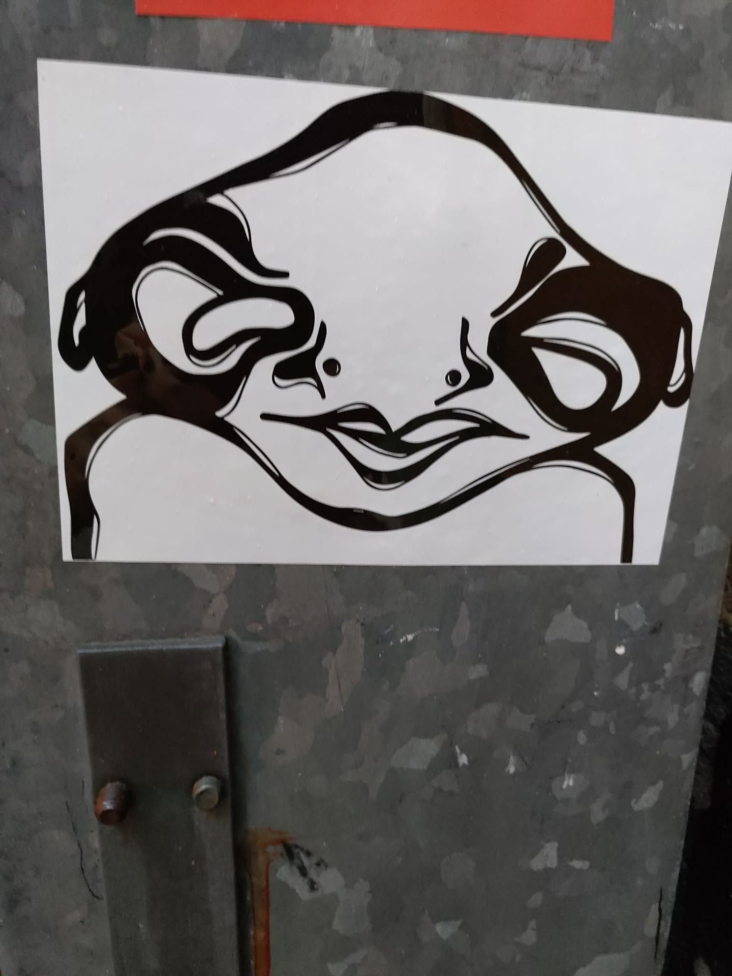 Black and white sticker featuring a stylized creature with a smooth, almost alien-like face. The creature's expression is subtle, neither happy nor sad, making it intriguing and mysterious. The artwork is minimalistic yet striking, using bold lines and negative space to create a memorable image.