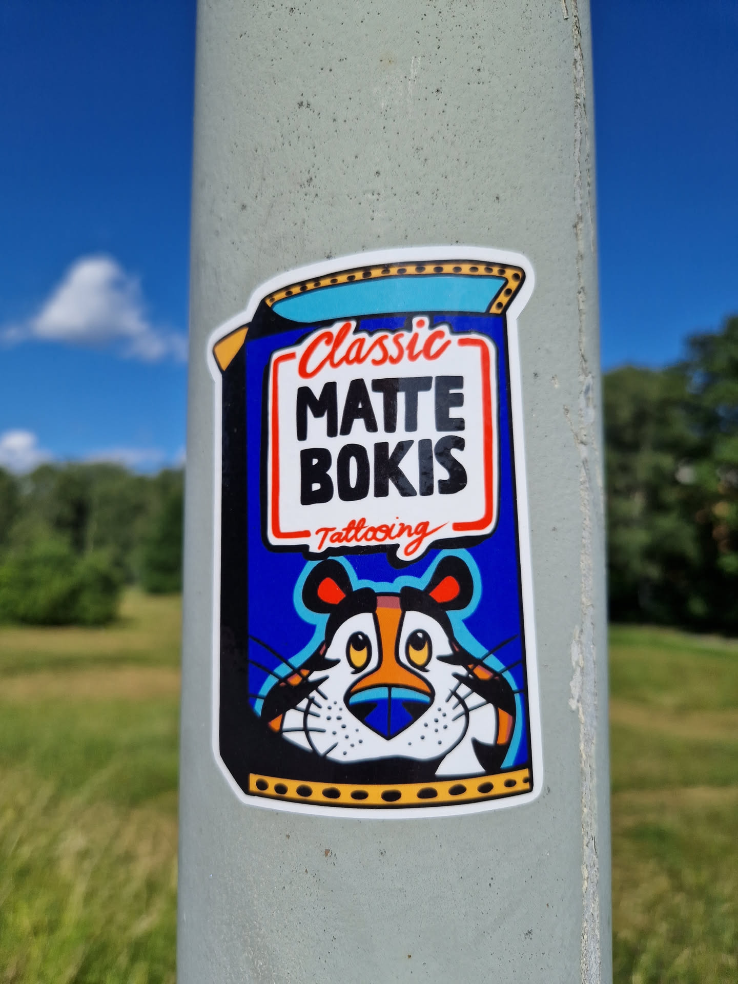 A sticker featuring a stylized Tony the Tiger from Frosted Flakes cereal, with the text 'Classic Matte Bokis Tattooing'. The style is reminiscent of vintage cereal box designs.