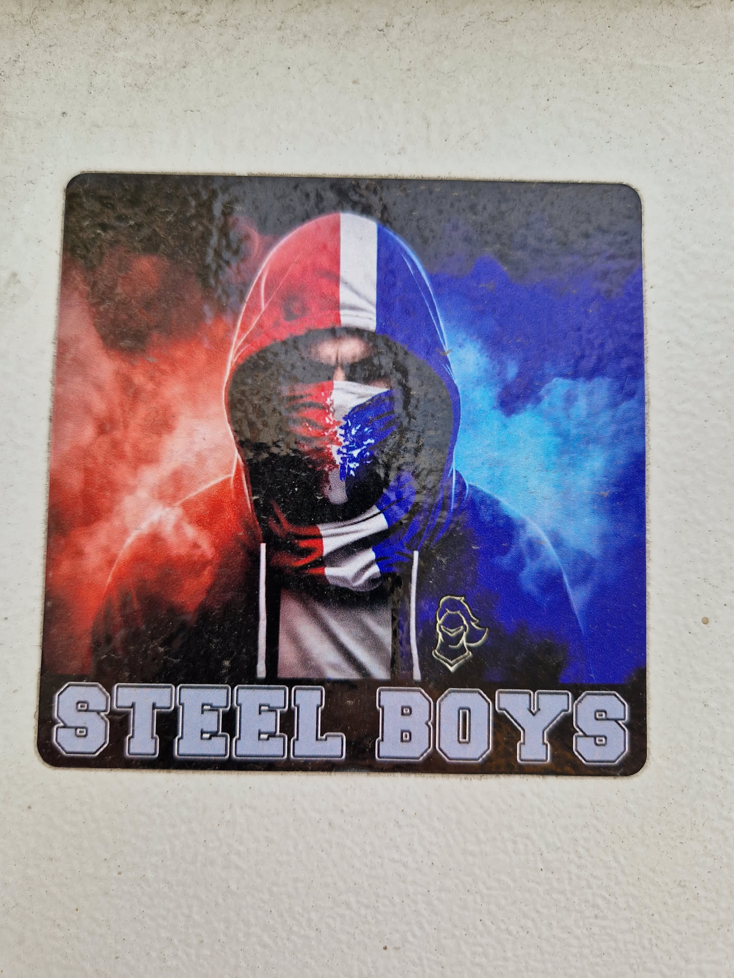 Sticker featuring a person wearing a hoodie with a French flag-themed face covering. The background is a blend of red and blue smoke or flames. The text "STEEL BOYS" is prominently displayed at the bottom.
