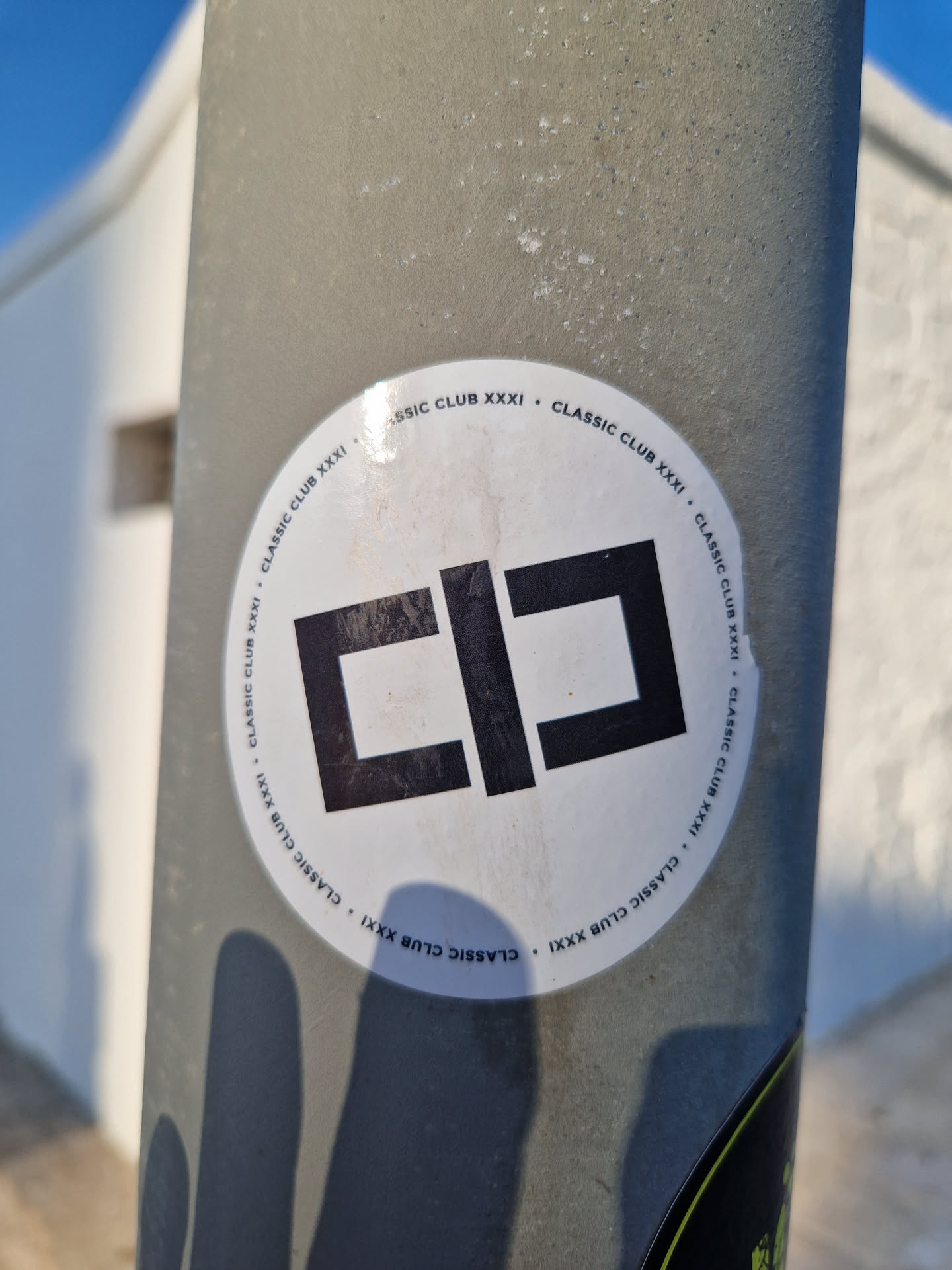 A round, white sticker with a black, stylized logo resembling the letters "CC" or a similar abstract design. The phrase "Classic Club XXXI" is written in a circular pattern around the logo.